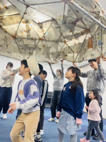 新聞紙ドームで遊ぶ子どもたち